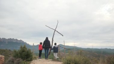 Dağlarda ahşap haçlar yakınında bir aile.