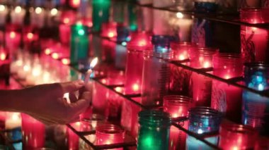 Arka planında bulanık mumlar olan yanan mumlu kadın.