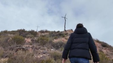 Dağlarda tahta haçlara yürüyen bir kadın.