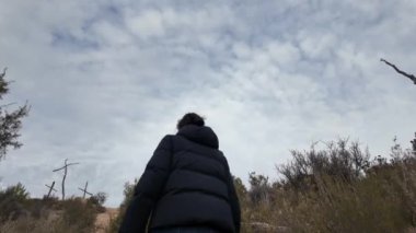 Dağlarda tahta haçların yanında bir kadın