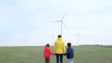 Anne ve oğulları kırsalda rüzgar türbinleri, ekoloji konsepti