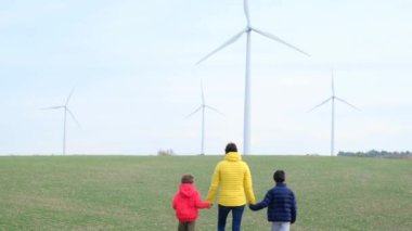 Anne ve oğulları kırsalda rüzgar türbinleri, ekoloji konsepti