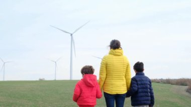 Anne ve oğulları kırsalda rüzgar türbinleri, ekoloji konsepti