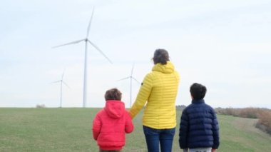 Anne ve oğulları kırsalda rüzgar türbinleri, ekoloji konsepti