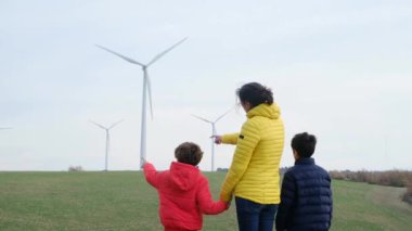 Anne ve oğulları kırsalda rüzgar türbinleri, ekoloji konsepti