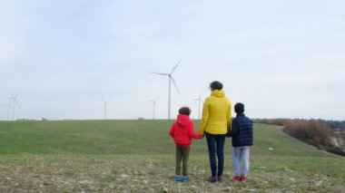 Anne ve oğulları kırsalda rüzgar türbinleri, ekoloji konsepti