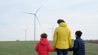 Anne ve oğulları kırsalda rüzgar türbinleri, ekoloji konsepti