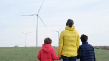 Anne ve oğulları kırsalda rüzgar türbinleri, ekoloji konsepti