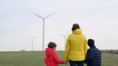 Anne ve oğulları kırsalda rüzgar türbinleri, ekoloji konsepti