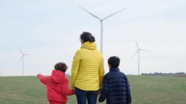 Anne ve oğulları kırsalda rüzgar türbinleri, ekoloji konsepti