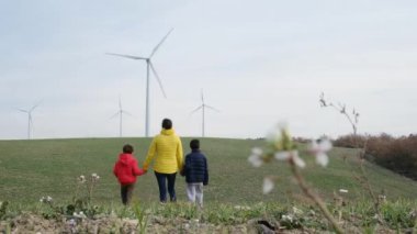 Anne ve oğulları kırsalda rüzgar türbinleri, ekoloji konsepti