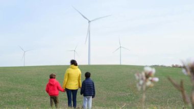 Anne ve oğulları kırsalda rüzgar türbinleri, ekoloji konsepti