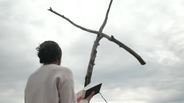 Женщина Молится Библией Возле Деревянного Креста Горах — стоковое видео