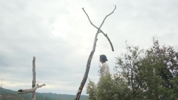 在山中木制十字架附近祈祷的女人 — 图库视频影像