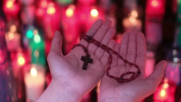 一个人的手 一个女人在教堂里用十字架在蜡烛前祈祷 耶稣基督 对宗教和神的希望和信仰 对心灵的专注和内心的平静 — 图库视频影像