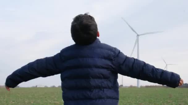 Chłopiec Wyciągniętymi Rękami Wsi Patrząc Turbiny Wiatrowe Koncepcja Ekologii — Wideo stockowe