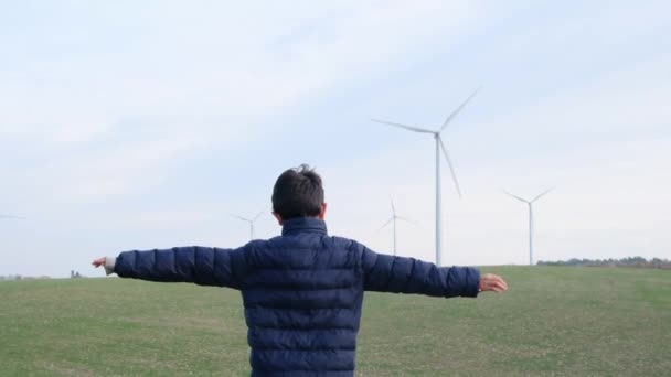 Хлопчик Руками Простягнувся Сільській Місцевості Дивлячись Вітрові Турбіни Концепція Екології — стокове відео