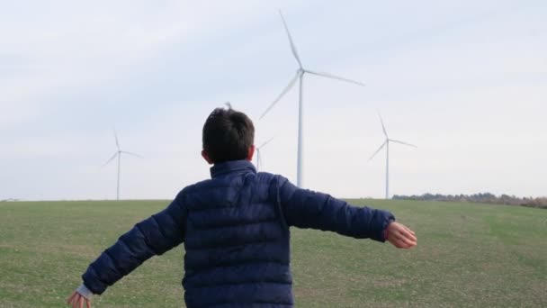Jongen Met Uitgestrekte Handen Het Platteland Kijken Naar Windturbines Ecologie — Stockvideo