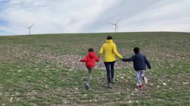 Anne ve oğulları kırsalda rüzgar türbinleri, ekoloji konsepti