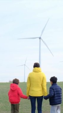 Anne ve oğulları kırsalda rüzgar türbinleri, ekoloji konsepti