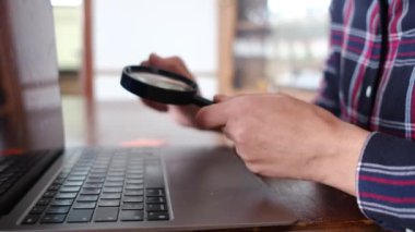 Büyüteçli bir kadın dizüstü bilgisayarı araştırıyor. İnternet ve bilgisayar sitelerini arama kavramı. Seyahat, finans, keşif ve bilgi. İnternet arama kavramını kullan.