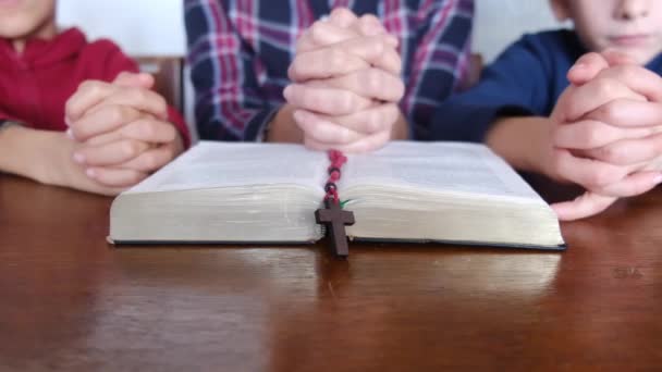 Νεαρή Μητέρα Τους Γιους Της Προσεύχονται Βίβλο Και Σταυρό — Αρχείο Βίντεο