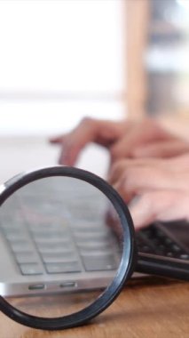 Dizüstü bilgisayar kullanan kişi. Büyüteç masanın üstünde. güvenlik kavramı