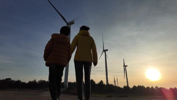 Madre Joven Con Hijo Campo Caminando Turbinas Eólicas Atardecer Concepto — Vídeos de Stock