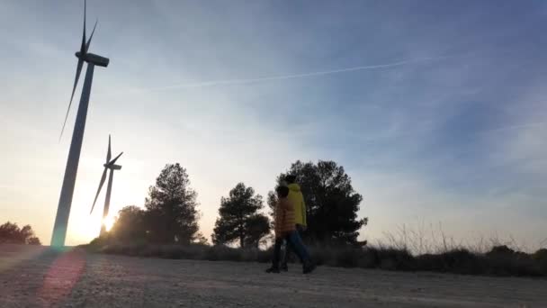 Ung Mor Med Son Landet Promenader Till Vindkraftverk Vid Solnedgången — Stockvideo