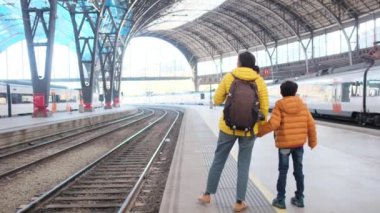 Tren istasyonunda oğlu olan genç bir anne gezgin. 