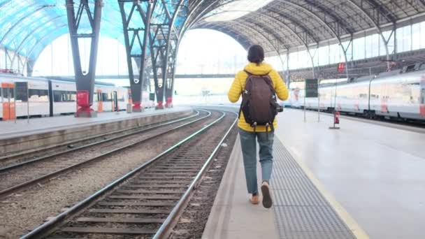 stock video young woman traveler with backpack walking on platform on train station 