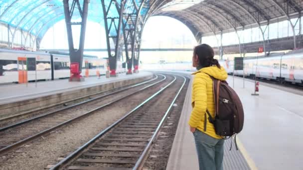 鉄道駅プラットフォームのバックパック付きの若い女性旅行者 — ストック動画
