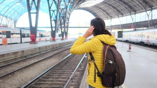 鉄道駅プラットフォームのバックパック付きの若い女性旅行者 — ストック動画