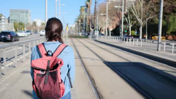 年轻女人背着背包在车站等电车在白天 幸福的城市生活冒险 — 图库视频影像