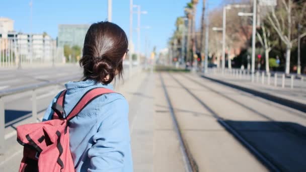 年轻女人背着背包在车站等电车在白天 幸福的城市生活冒险 — 图库视频影像