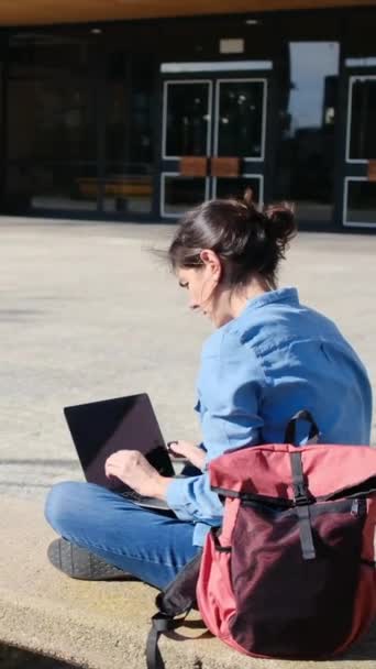 彼女のラップトップとキャンパスで勉強することに没頭した大学の学生は 彼女のEラーニングの旅に自信を持って屋外の静けさを受け入れます — ストック動画