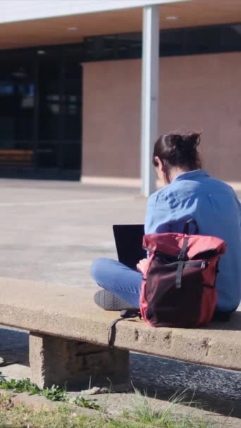 一名大学生带着笔记本电脑在校园里专心致志地学习 对自己的网上学习充满了信心 她拥抱了户外的宁静 — 图库视频影像
