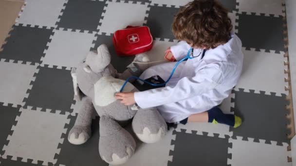 Anak Kecil Mengenakan Jubah Medis Dengan Stetoskop Bermain Dengan Mainan — Stok Video