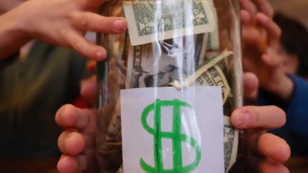 Kisfiúk Gyűjtése Dollár Bankjegyek Üveg Megtakarítás Miközben Asztal — Stock videók
