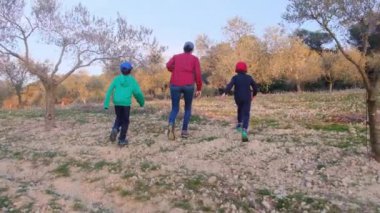 Dijital tabletli anne ve oğlu güneşli bahar gününde meyve bahçesini kontrol ediyor.