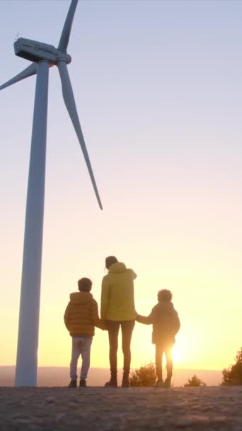 日落时分 母亲和儿子们一起在风力涡轮机旁 — 图库视频影像