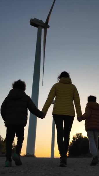 Moeder Zonen Wandelen Bij Windturbines Samen Bij Zonsondergang — Stockvideo