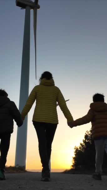 Anne Oğulları Gün Batımında Rüzgar Türbinlerinin Yanında Yürüyorlar — Stok video