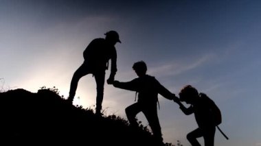 Güneşli bir günde anne ve oğulların silueti birlikte dışarıda vakit geçiriyorlar.