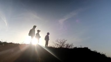 Güneşli bir günde anne ve oğulların silueti birlikte dışarıda vakit geçiriyorlar.