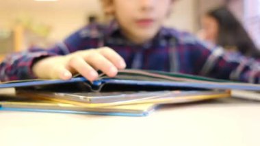 Bulanık küçük çocuk masada kitap okuyor.