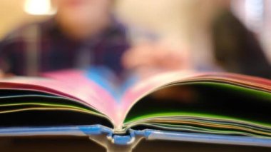 Bulanık küçük çocuk masada kitap okuyor.