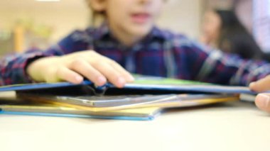 Bulanık küçük çocuk masada kitap okuyor.