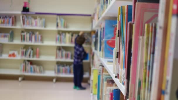 Мальчик Выбирает Книги Библиотеке — стоковое видео