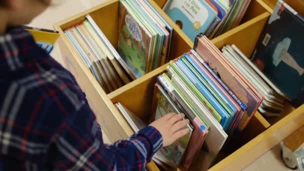Niño Eligiendo Libros Biblioteca — Vídeo de stock